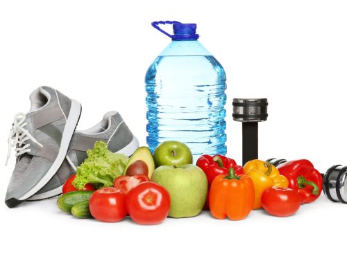 Comida sana, pesas y zapatillas de deporte sobre fondo blanco que representan el concepto de pérdida de peso / Healthy food, dumbbells and sneakers on white background. Concept of weight loss